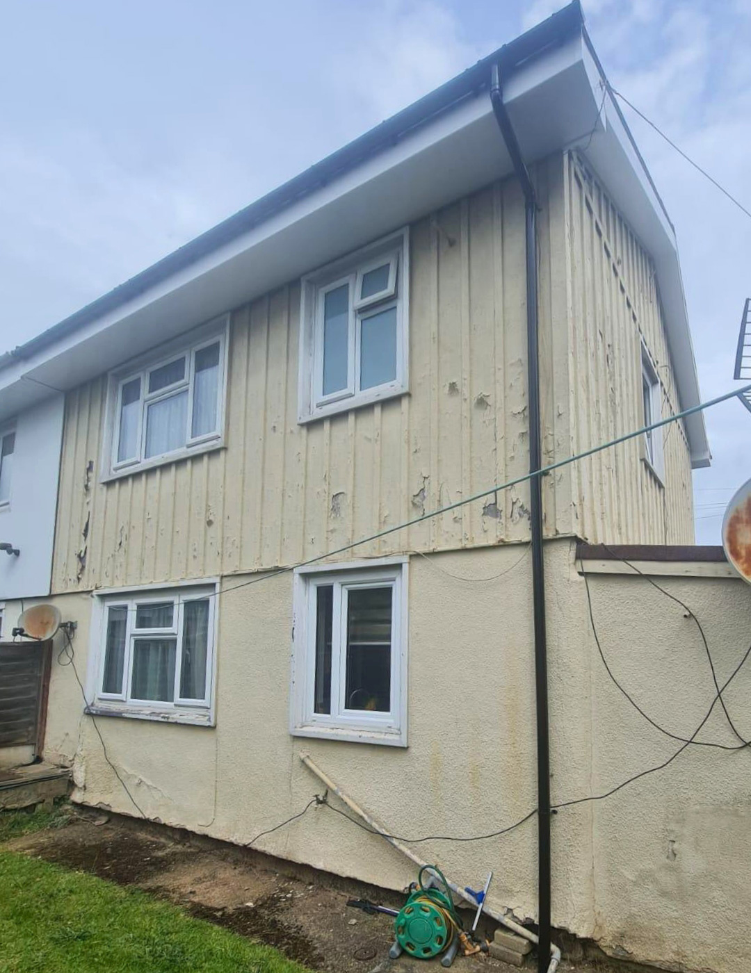 Leamington Spa Property - Before Professional Rendering Dated yellow cladding and cracked render in Leamington Spa before facade modernisation.