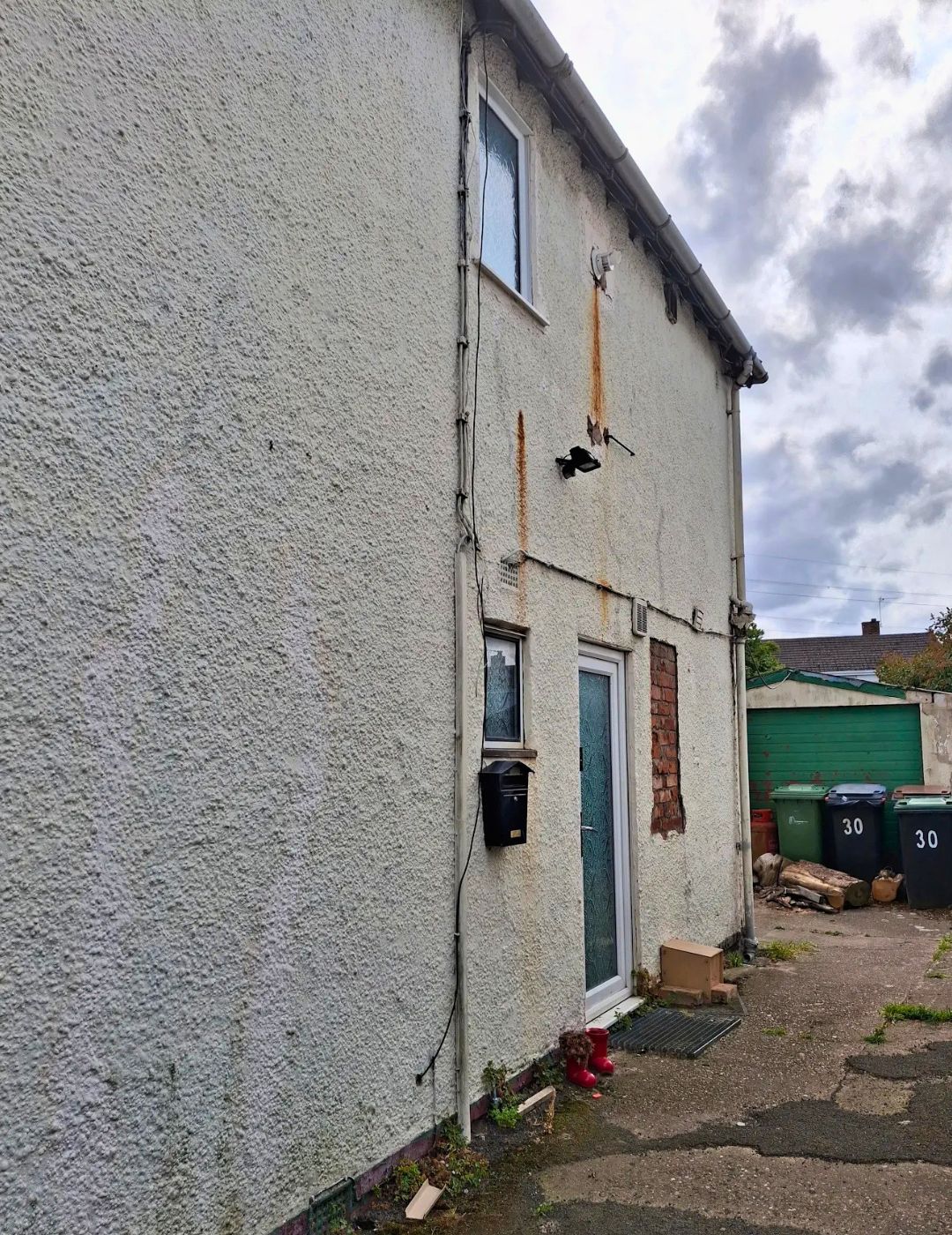 Weathered pebbledash side elevation in Derby with rust staining before silicone render by PD Rendering