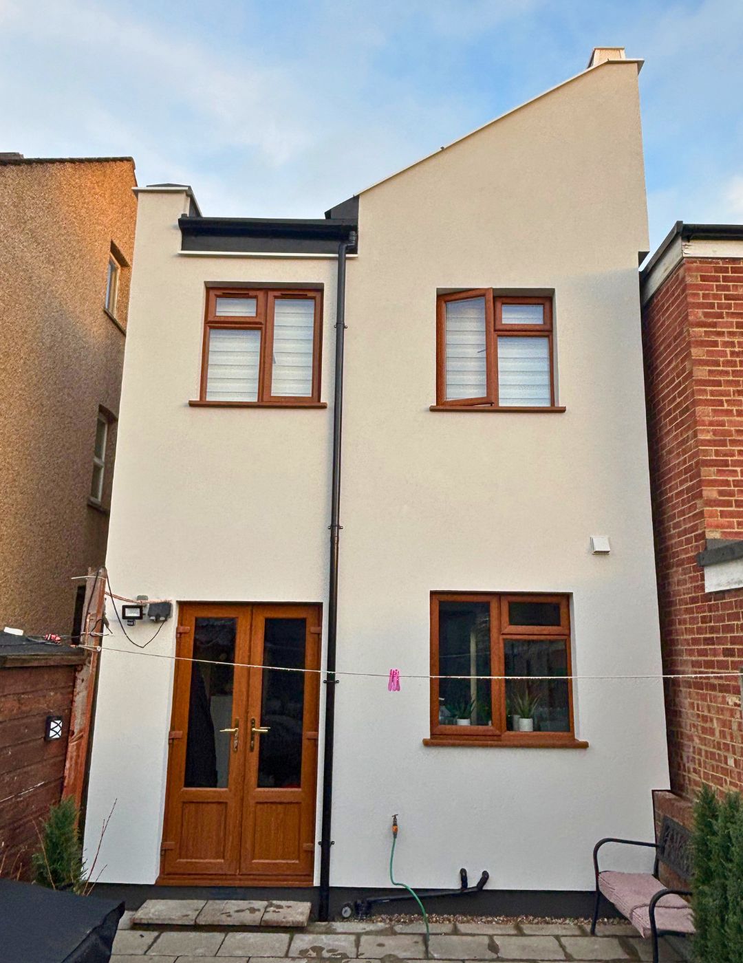 Hinckley property rear finished in warm cream silicone render with golden oak windows by PD Rendering