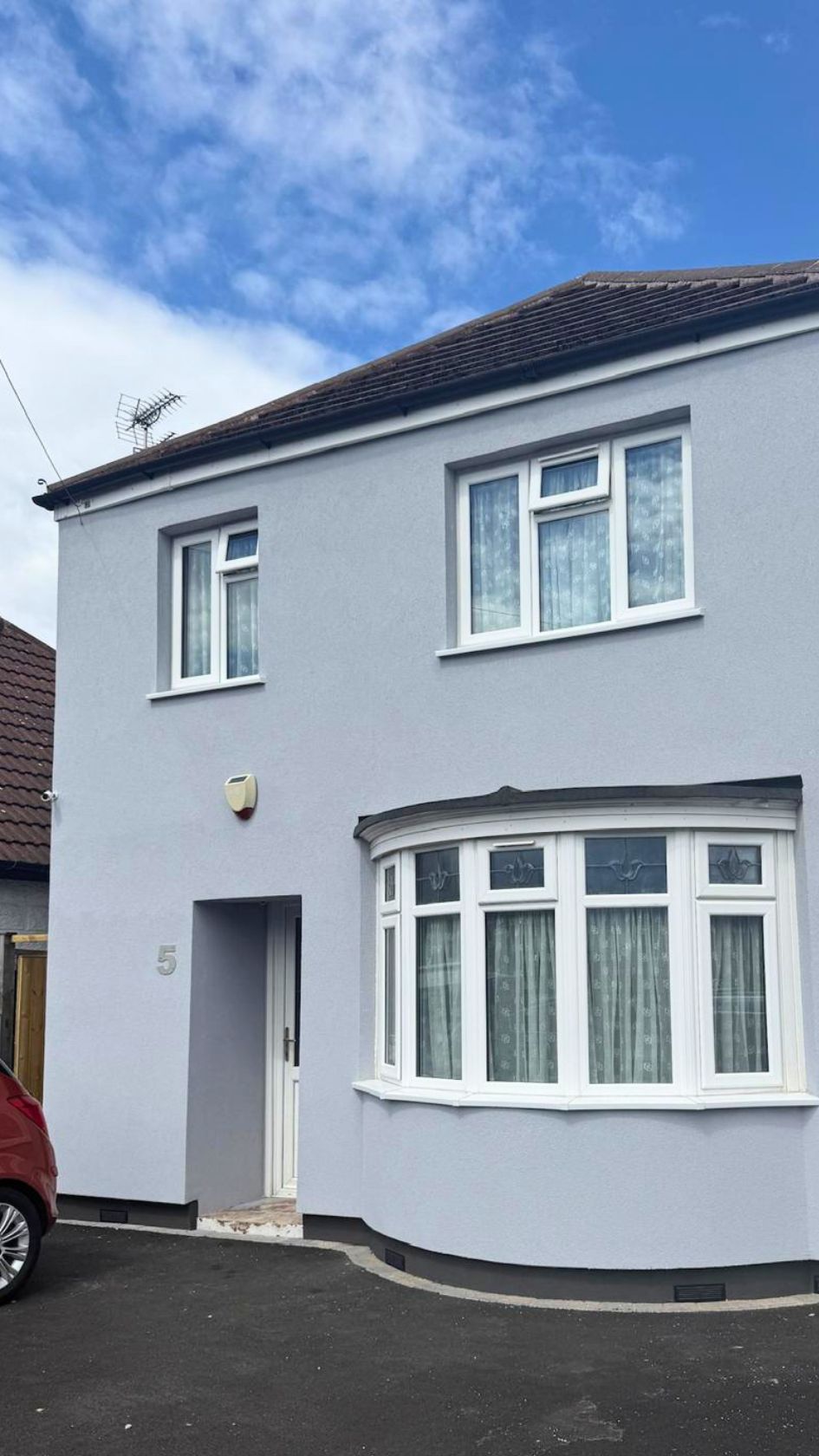 Semi-detached house with bay windows fully insulated and finished in a smooth light grey silicone render.