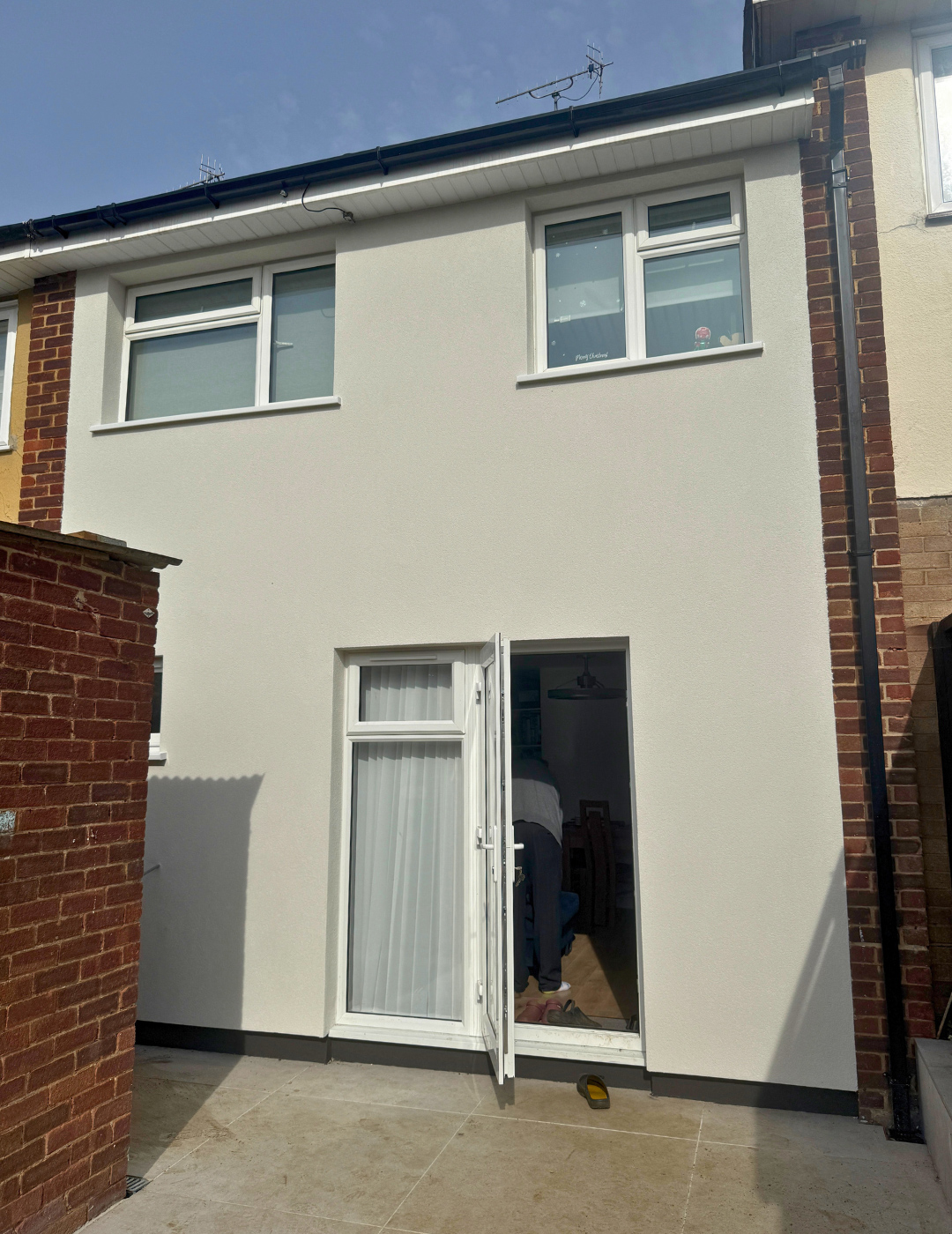 Professional white silicone render application on a London terraced house facade by PD Rendering.