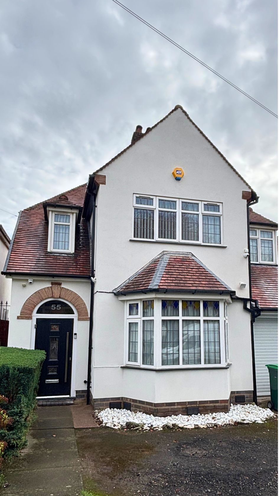 Fully rendered house in white silicone finish, retaining original architectural brick details around the front entrance.